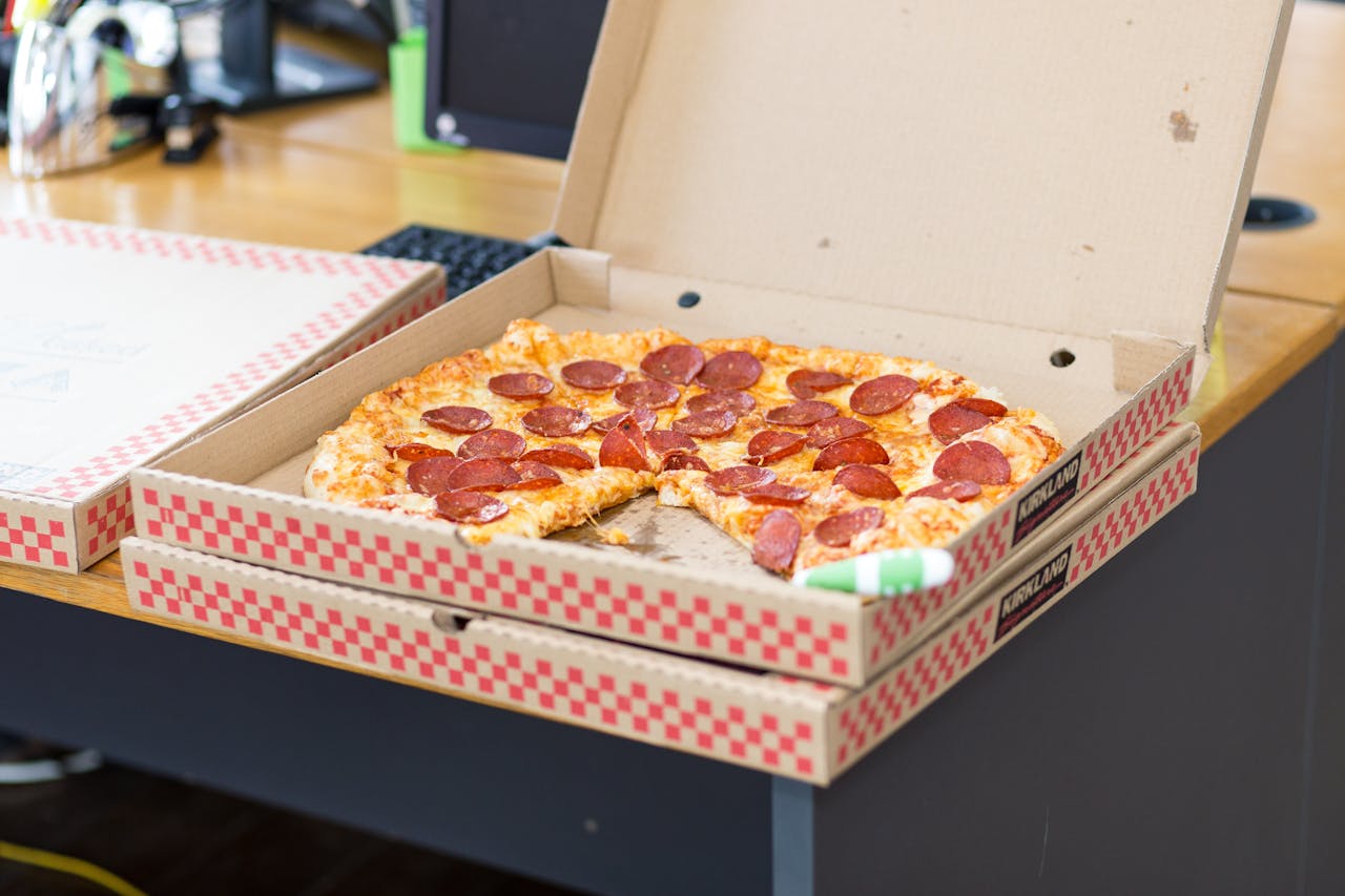 gallery-04 Delicious pepperoni pizza in an open box on a desk, perfect for a quick meal.