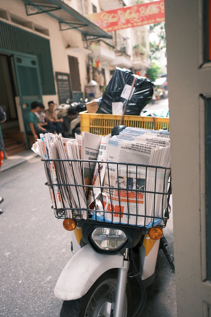 services-02 A scooter packed with newspapers and parcels on a bustling Jakarta street.